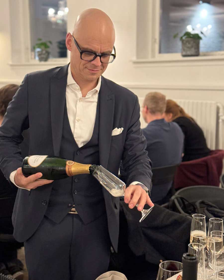 Matthias Renner mit Champagnerflasche beim Einschenken