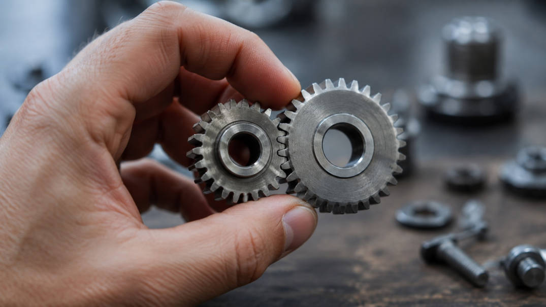 A hand holds two interlocking gears, symbolic image for Papert's constructionism